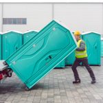 Rental,Lavatory,Being,Loaded,On,Truck,By,Worker